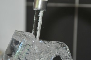 Trinkwasser aus der Leitung fließt in ein Glas